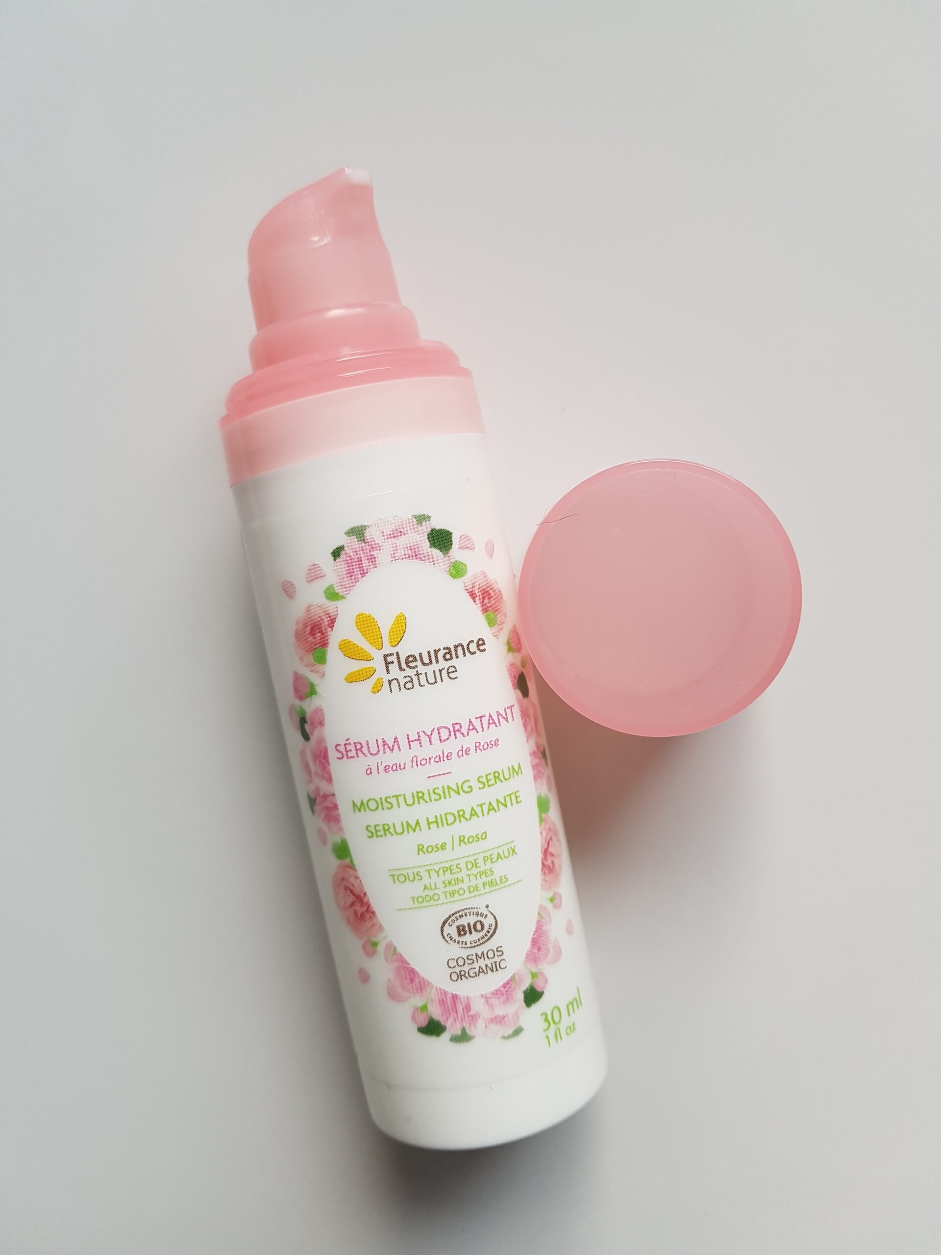 Flacon pompe blanc et rose d'une crème hydratante à l'eau florale de rose